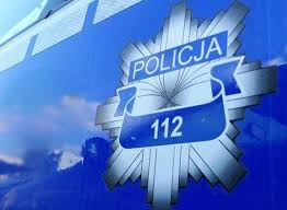 Gwiazda policyjna z napisem Policja oraz numerem 112 zamieszczona na bocznych drzwiach oznakowanego radiowozu policyjnego